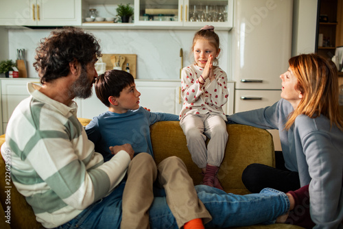 Girl telling a story to her family on the sofa