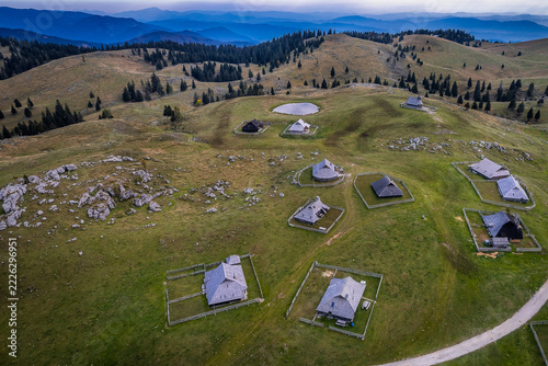 Aerial View of Traditional Shepherd Huts and Mountain Pond on Velika Planina, Slovenia
