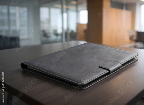 A flat, dark grey or black textured object, resembling a premium leather mousepad or a sleek presentation folder, cleanly isolated on a white background
