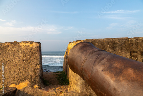 Old cannon pointing through an embrasure in the old fort wall toward the sea, Southern Province, Galle, Sri Lanka