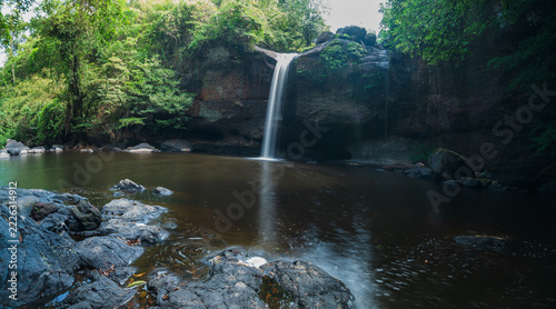 Serene Waterfall in Yai Surrounded by Lush Greenery and Rocks