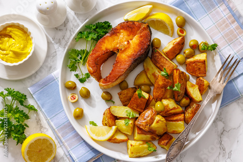 Pan seared salmon steak with potato wedges