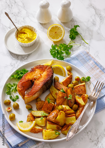 Crispy grilled salmon steak with potato wedges