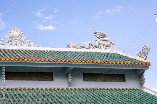 Dragon reliefs on a green tiled roof in Da Lat Vietnam