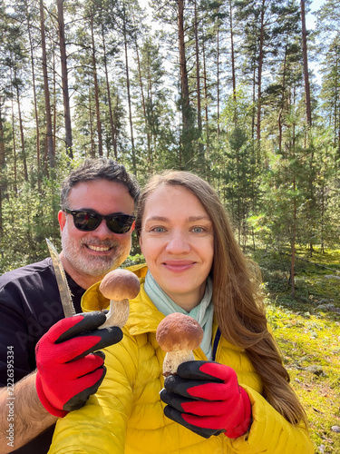 Couple Collects Mushrooms in Forest During Sunny Day