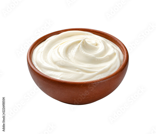 Fresh sour cream in a ceramic bowl isolated on a plain white background for design