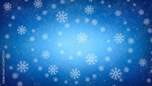 Abstract blue winter background featuring delicate white snowflakes falling in a vortex with glowing light and snowfall particles creating a festive Christmas holiday atmosphere