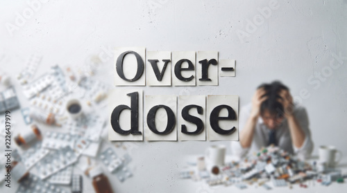 「Overdose」の文字と薬物の過剰摂取に悩む男性