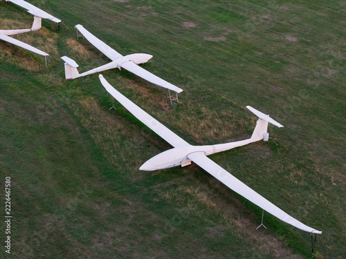 Aerial view of white gliders parked on a grassy airfield in the United Kingdom.