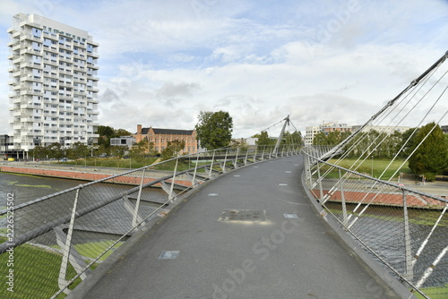 Obraz na plátně La passerelle enjambant le canal et la tour résidentielle futuriste à Courtrai (
