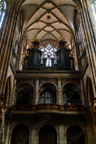 Prague, Czechia - 05 October 2026: View of the ornate pipe organ inside St. Vitus Cathedral, featuring intricate gold detailing, vaulted stone ceilings, and gothic architecture.