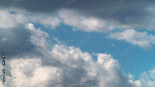 Time-lapse of fluffy white cumulus clouds moving across blue sky
