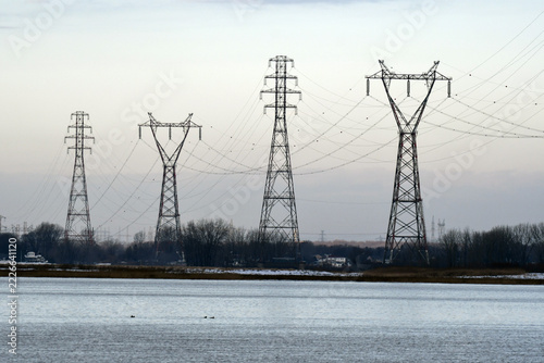 electricity pylons at sunset, under a blue sky