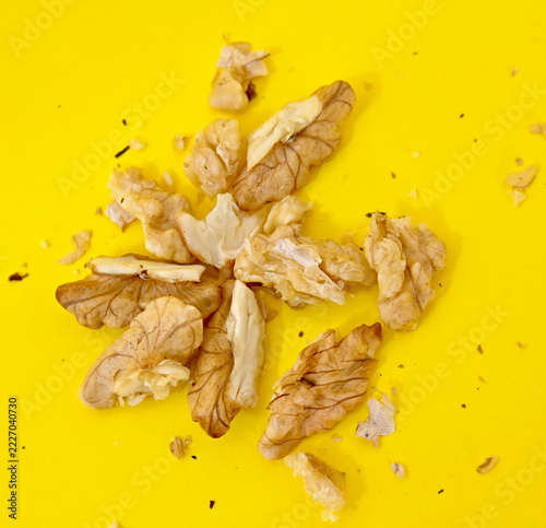 Freshly cracked walnut kernel on yellow background