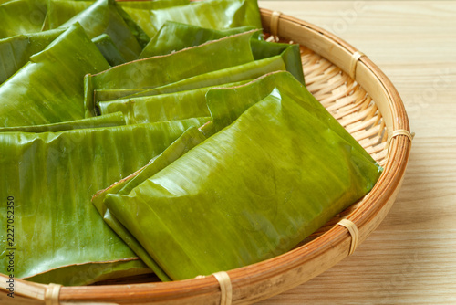 leaf wrapped rice cake, banana leaves, bamboo basket, moochi, Yaeyama food, traditional food, close up, natural packaging, kanapamuchi, folded leaves, mochi, rice cake, food wrapping, leaf parcels, Ja