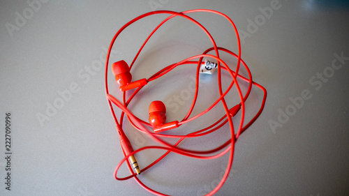 Tangled Red Wired Earphones on Grey Surface