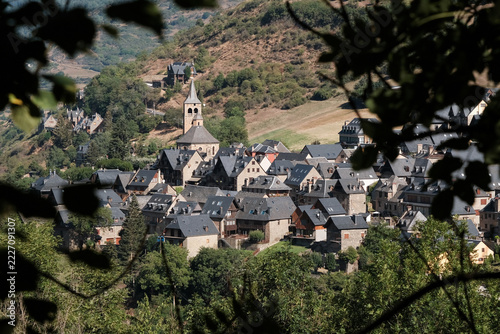 View through the foliage of Vilac village on sunny summer day. Aran Valley, Catalan Pyrenees, Spain.