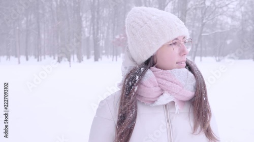 Woman winter portrait. Young female enjoying snowy outdoors. Calm lifestyle concept.