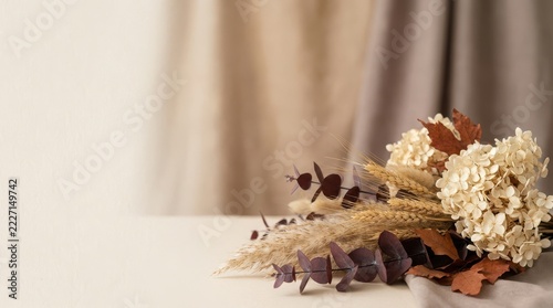 Rustic dried flower bouquet resting on a table against soft draped fabric