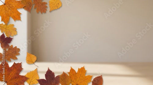 Assorted colorful autumn foliage frame on a light beige wooden textured