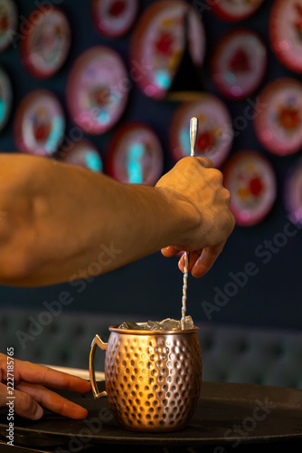 Photography Bartender Stirring Moscow Mule in Hammered Copper Mug at Bar