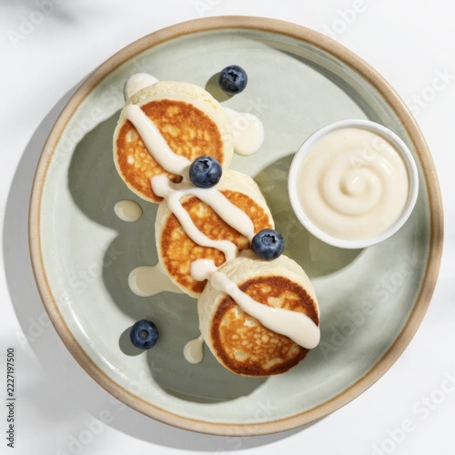 Premium overhead shot of golden brown cottage cheese pancakes with glossy sweetened condensed milk drizzle — flat lay food styling for morning meal and brunch idea culinary photography