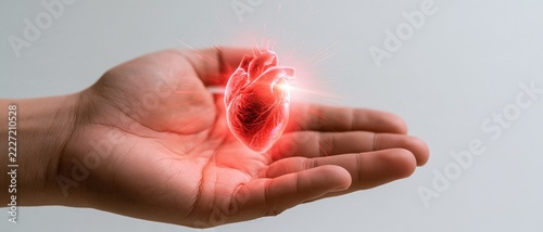 Hand cradles glowing red heart
