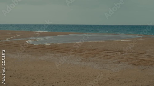 Ocean water advances across wet sand at Newport Beach as high tide reaches farther up the shore.