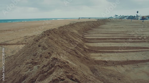 Tall sand berms run along Newport Beach creating a protective wall against high tides and waves.