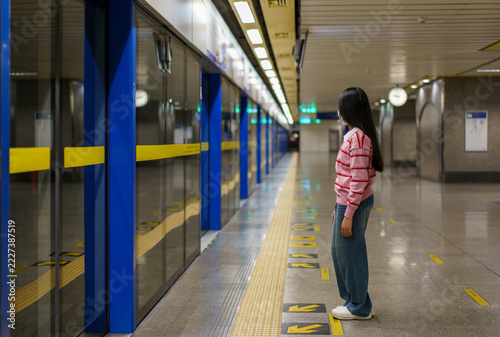 Fotografie Asian child or kid girl waiting sky train or electric train with underground rai