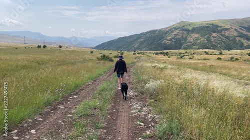 woman walking with dog in mountains