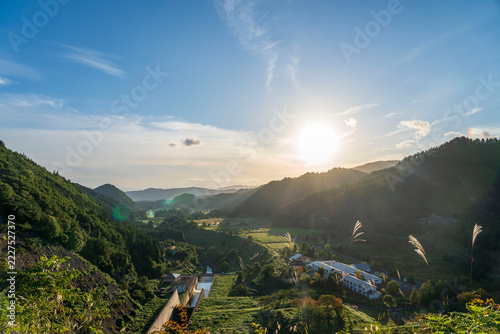 福島県喜多方市　夕日に照らされた山村を日中ダムの堤体から望む