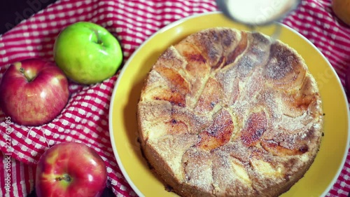 Sieve dusting powdered sugar apple cake. Top view baked pie red green apples.