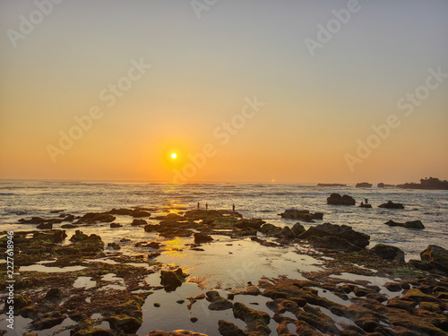 Golden Sunset Over Rocky Coastline and Calm Ocean Tide Pools