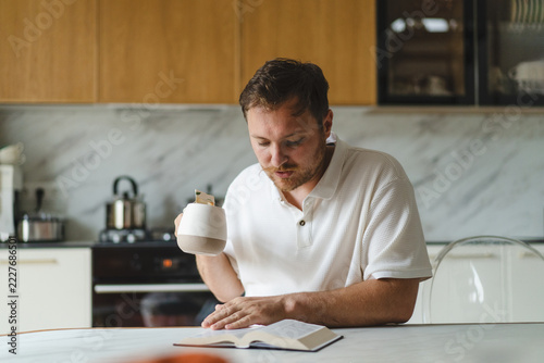 Man read Bible and pray at kitchen table