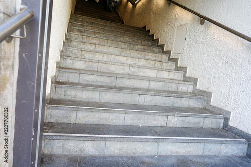 Obraz na plátně Empty gray stone staircase descending indoors beside textured white walls and me