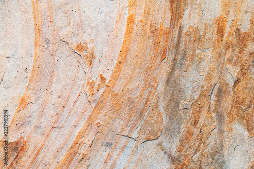 Abstract rock surface with orange mineral stains weathered sandstone geological texture