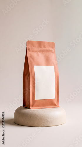 Peach coffee pouch mock up on a rounded stone pedestal display