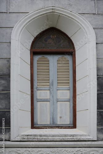 A beautiful vintage-style wooden window with faded paint.