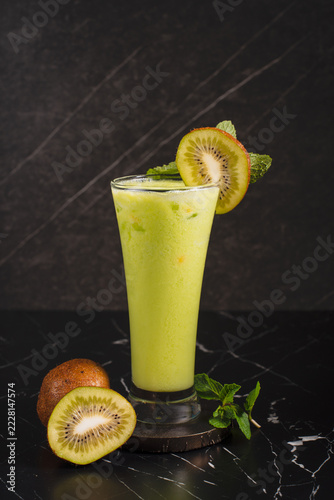 Fotografie Refreshing Kiwi Smoothie on Black Marble.