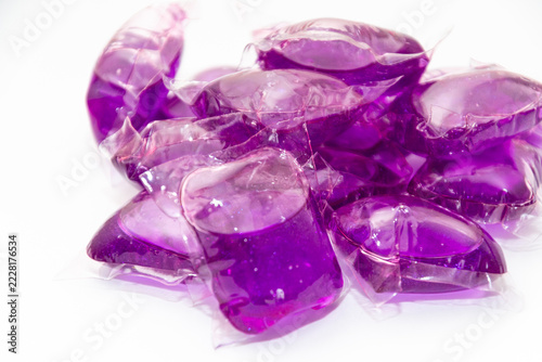 gel capsules with laundry detergent on light background