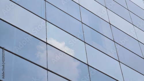 a close-up, low-angle view of a modern skyscraper's glass curtain wall