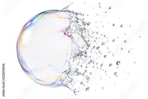 Extreme close-up of a transparent soap bubble bursting into tiny droplets.