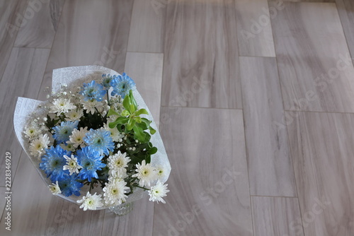Bouquet of blue and white flowers in vase on the floor.there is space for text