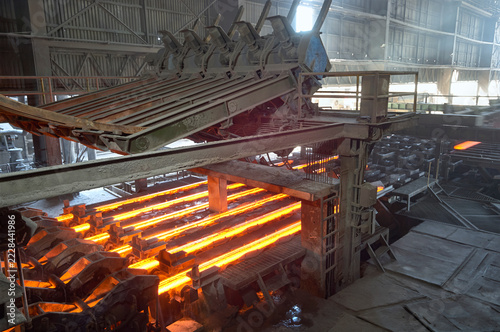 Glowing red hot steel billets processing on a continuous casting machine in a heavy industrial steel mill