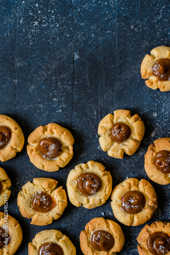 Salted caramel thumbprint cookies on blue background