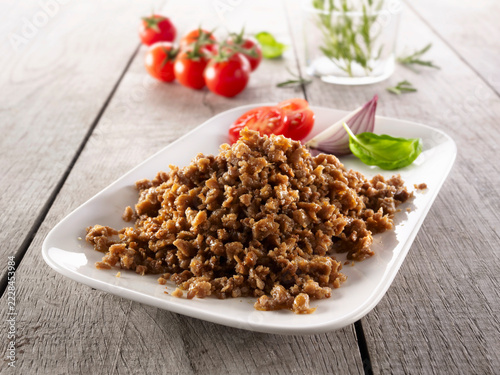 Fried soy mince with tomato and basil on plate
