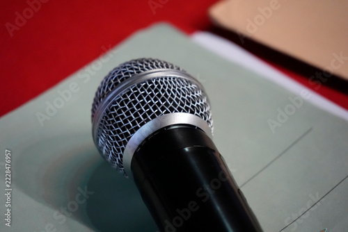 Dynamic Microphone Resting on Notebook with Red Background