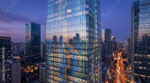 Modern Skyscraper at Dusk: A contemporary glass skyscraper stands tall amidst a bustling cityscape as twilight descends, its illuminated facade reflecting the vibrant energy of urban life.