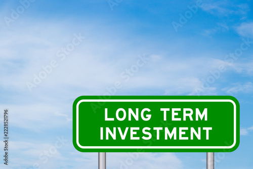 Green color transportation sign with word long term investment on blue sky with white cloud background